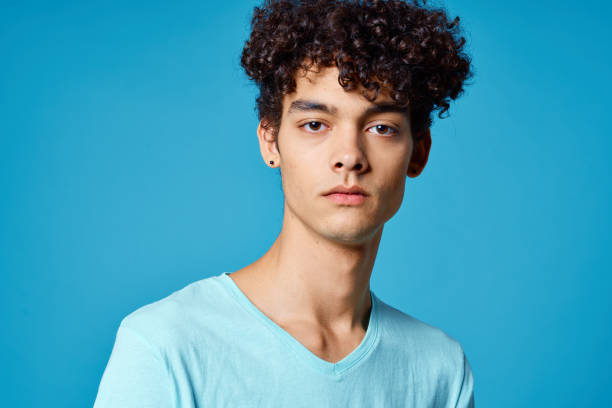 istock cute guy curly hair blue t-shirt isolated background 2052652546