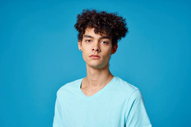 istock guy with curly hair in blue t-shirt cropped view studio 2052657736