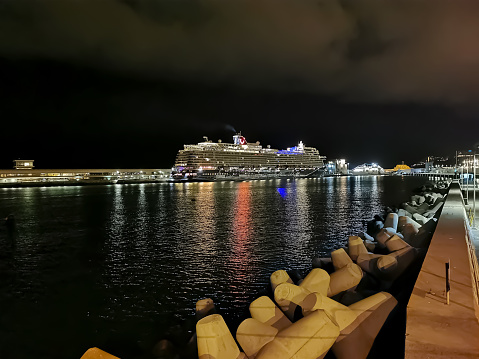 Night view of a cruise ship moored in the city of Funchal, magnificent effect of lights on the water and the city, in downtown Funchal, Madeira Island, Portugal,,,