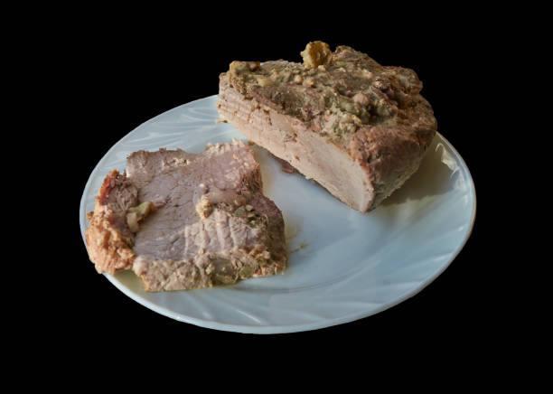 Plate with pieces of baked pork meat, macro, isolated on black. stock photo