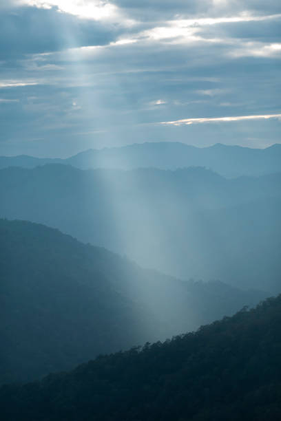 istock Sun rays filter through the clouds in hills of the valley illuminated by the sun's rays filtering through the clouds 2052729941