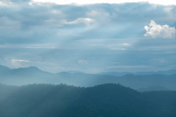 Sun rays filter through the clouds in hills of the valley illuminated by the sun's rays filtering through the clouds