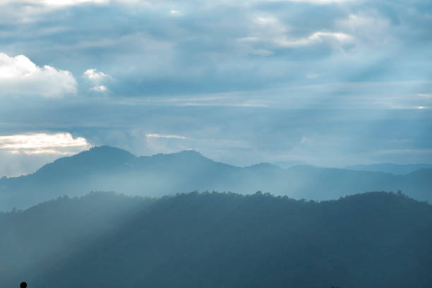 Sun rays filter through the clouds in hills of the valley illuminated by the sun's rays filtering through the clouds