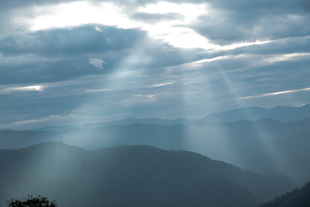 istock Sun rays filter through the clouds in hills of the valley illuminated by the sun's rays filtering through the clouds 2052729949