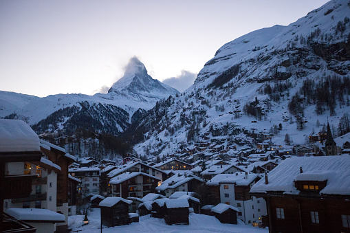 Normally hidden behind the clouds, the Matterhorn emerges on a clear day over the village of Zermatt in Southern Switzerland