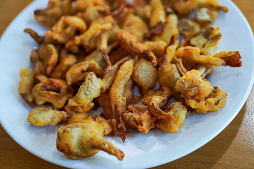 Close-up image of homemade crispy oyster mushrooms on a plate at a dining table.