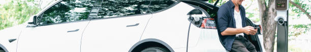 istock Man using smartphone to pay for electric car charging. Exalt 2052753031