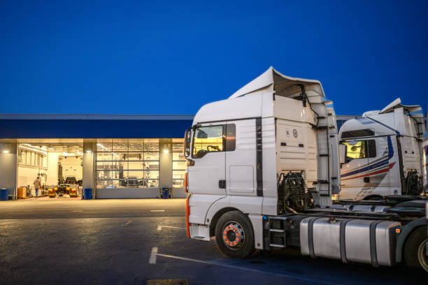3D rendering of contemporary white trucks with trailer parked in modern spacious hangar in sunlight