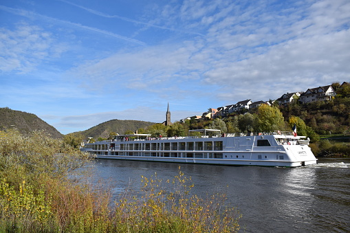 Kobern-Gondorf, Germany - 10/26/2022: passenger ship on the Mosel with autumn vineyards