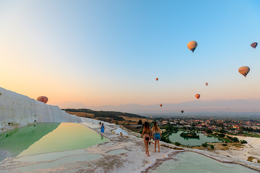 Pamukkale, Turkey - Aug 7,2023: Visitors to Pamukkale can walk barefoot on the terraces, where the warm, calcium-laden water creates shallow pools and cascades, resembling fluffy cotton.