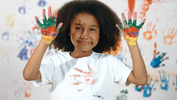 istock African student put hands up together show colorful stained hands. Erudition. 2052768801