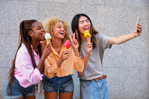 istock Three multiracial happy friends with ice creams taking a selfie in summer. 2052778689