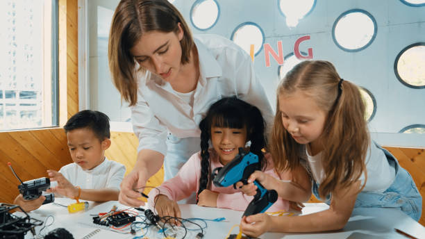 istock Teacher looking at children while diverse student looking at screen. Erudition. 2052798116