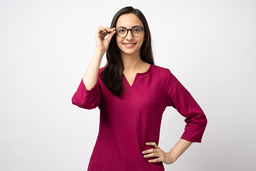 Portrait of attractive cheerful girl touching specs looking at camera copy space isolated over white color background