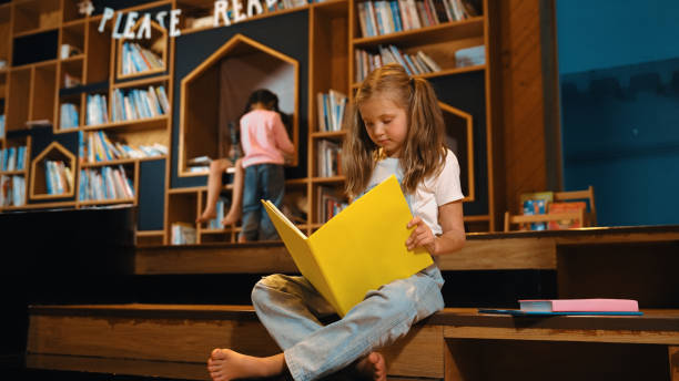 istock Smart caucasian girl picking reading a book while sitting at library. Erudition. 2052834402