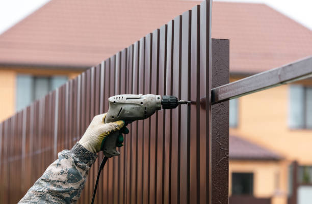 istock Workers install a metal profile fence 2052836040