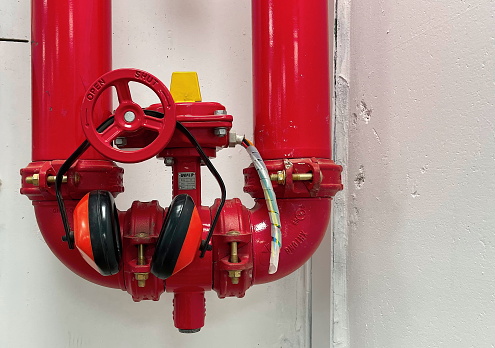 Essential Fire Safety Equipment. Bright Red Standpipe System with Hearing Protection Headphones Indoor