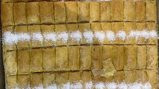 Golden Rows of Turkish Baklava. Delicious Pastry Topped with Fragrant Syrup and Coconut. Top View