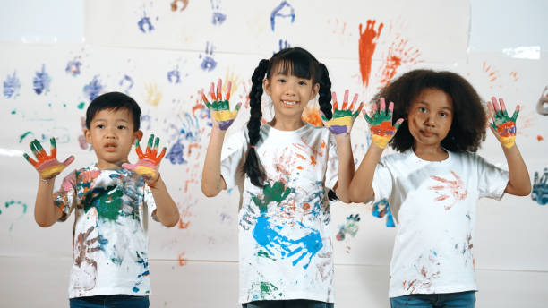 istock Diverse students put hands up together show colorful stained hands. Erudition. 2052855110