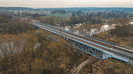 landscape of fields and meadows near the city on a spring day with a drone view of the architecture of the railway bridge, transport, communication and infrastructure