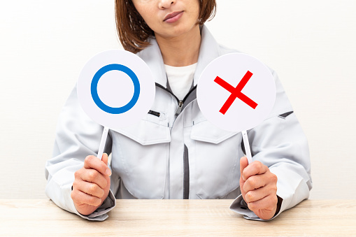 A woman answers using circle and cross placards.