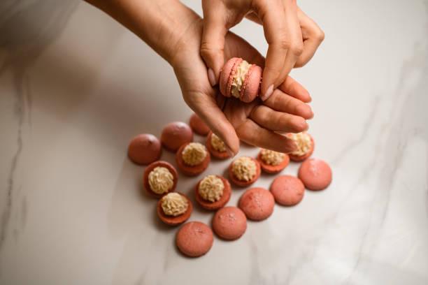 istock Crafting perfect beige macarons with a creamy filling. 2052867366