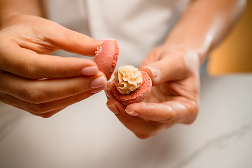 Series of images illustrating the process of creating beige macrons, filling them with creamy delight.