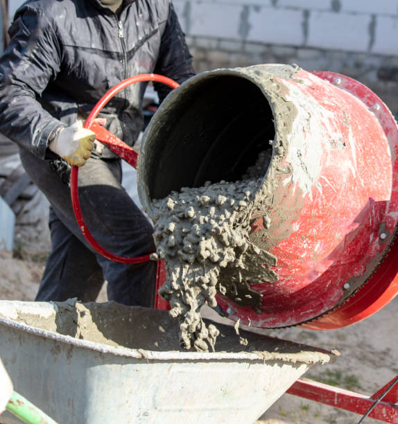 istock Worker pouring concrete with cement mixer at construction site, closeup 2052889757