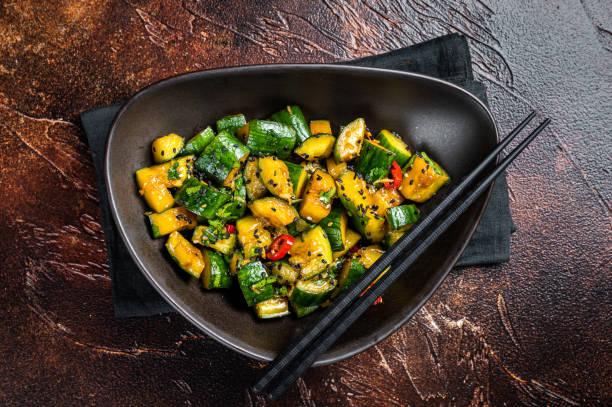 istock Chinese smashed cucumbers with herbs and sesame oil. Dark background. Top view 2052890875