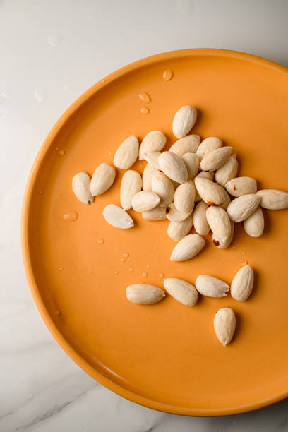 Peeled almonds arranged neatly on a simple plate