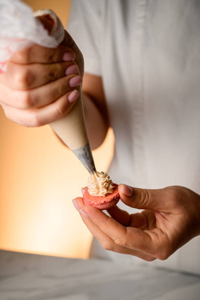 istock Crafting beige macrons, creamy filling on display. 2052919531