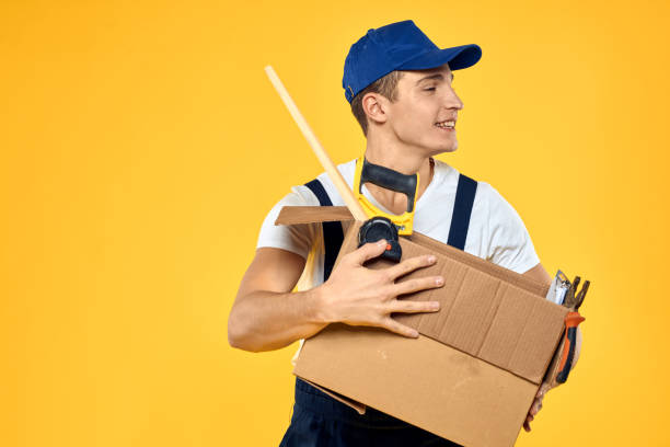 Warehouse worker moving hand truck loaded with cardboard boxes stack, view inside of delivery van. Courier with cart wide shot, freight transportation