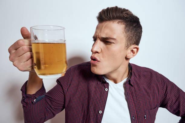 istock Cheerful man with mug of beer alcohol emotions light background 2052960340