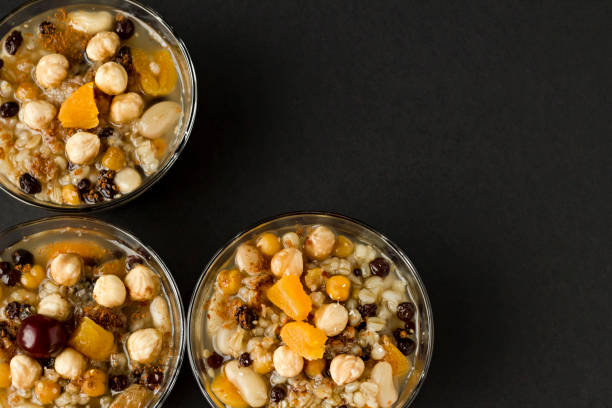istock Traditional Turkish Dessert Ashure or Noah's Ark Pudding in glass bowls on black surface 2052963485