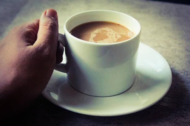 istock someone's hand is holding a cup, containing hot cappuccino coffee 2052973437