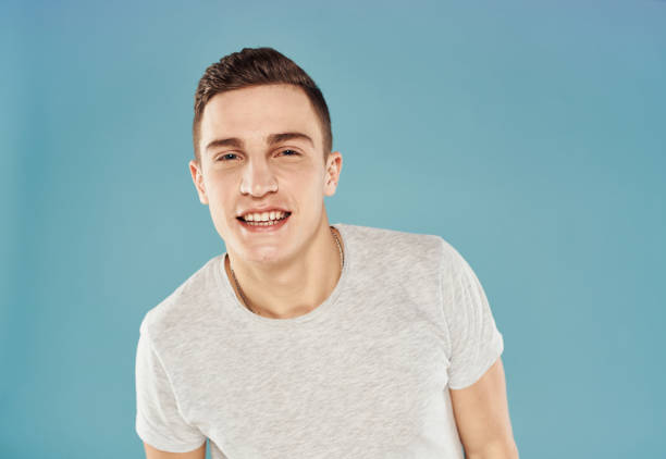 istock Smiling handsome man in white T-shirt blue background close-up 2052980537