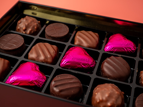 Box of chocolates on a pink background. Chocolate candies close-up.