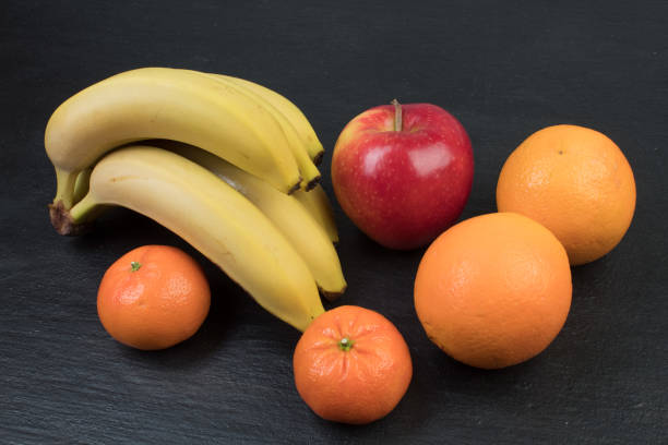 Fruits. Bananas, apples, oranges tangerines on a black background