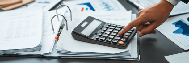 istock Corporate auditor calculating budget with calculator on his office desk. Insight 2053049577