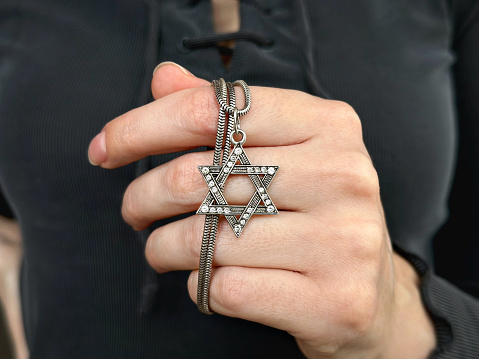 Young woman's hand holding a David Star (