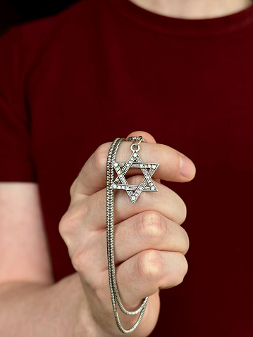 Young men's hand holding a David Star (