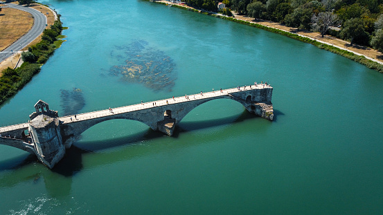 Broken bridge Saint-Bénézet in the city of Avignon in Provence. famous Avignon bridge over the Rhone depicted in paintings, poems, stamps. architecture seen from a drone with its arches. Historic bridge that attracts tourists from all over Europe. It once connected the island of Barthelasse.