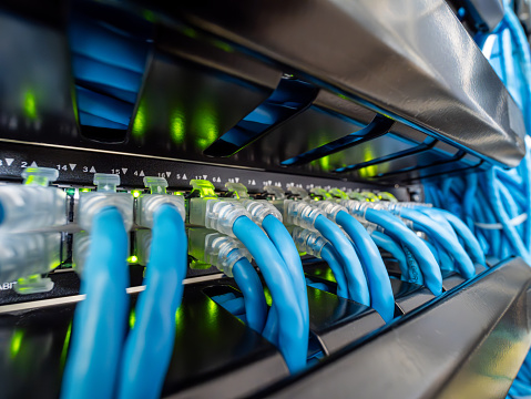 Network switch and ethernet cable in rack cabinet. Network connection technology and has a status LED to show working status. Concept of infrastructure with cables connected to data center