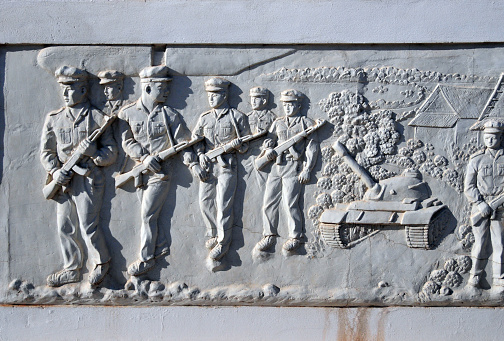 Vientiane, Laos: Revolution Memorial Tower - Unknown Soldier Monument, revolutionary struggle between 1945 to 1975 - Nong Sa Phang Lenh Park - frieze detail with war scene - advancing Pathet Lao troops and tank.