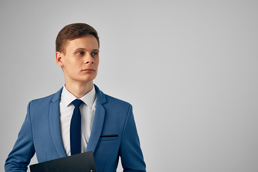 man in a suit with documents in his hands professional office light background. High quality photo