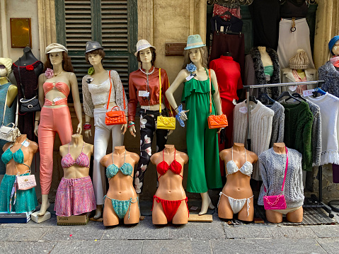 Casual summer wear including bikinis on display outside a shop.