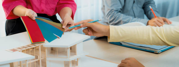 Architect and designer team collaborate to select house color theme. Variegated.