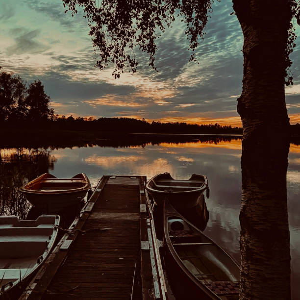 istock Boats and a canoe on the jetty after sunset 2053133208