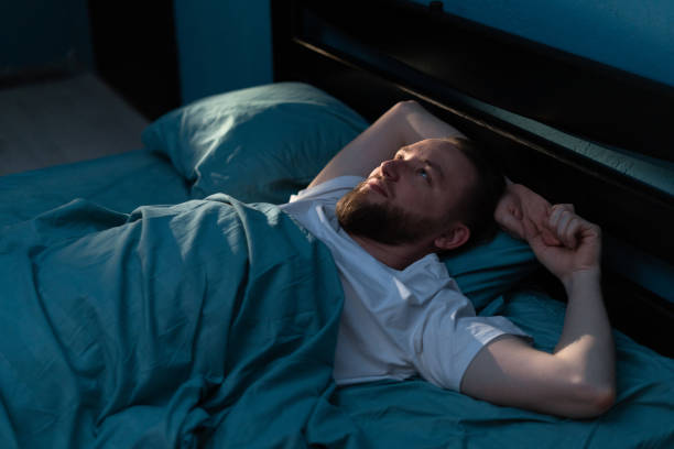 istock Stressed man feels from insomnia trying to sleep in his bed at night. 2053133448