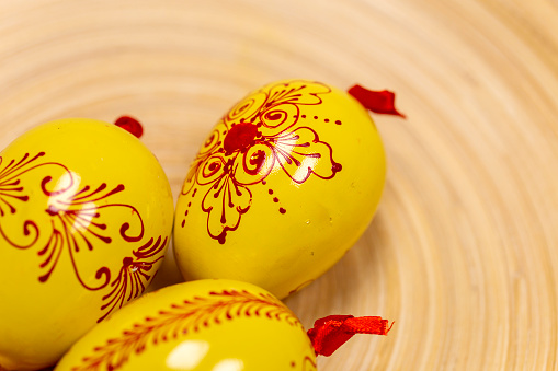 Wooden easter eggs on a bamboo tray.